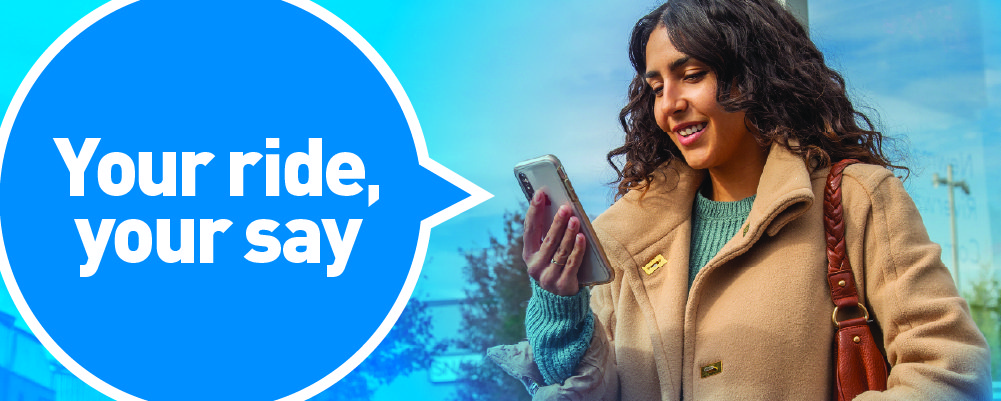 women wearing a coat looking at the phone in her hand