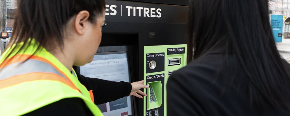 Customer service staff help a transit rider use the PRESTO self-serve machine