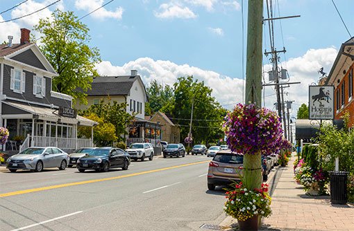 image of a street with quaint shops and cars on the road