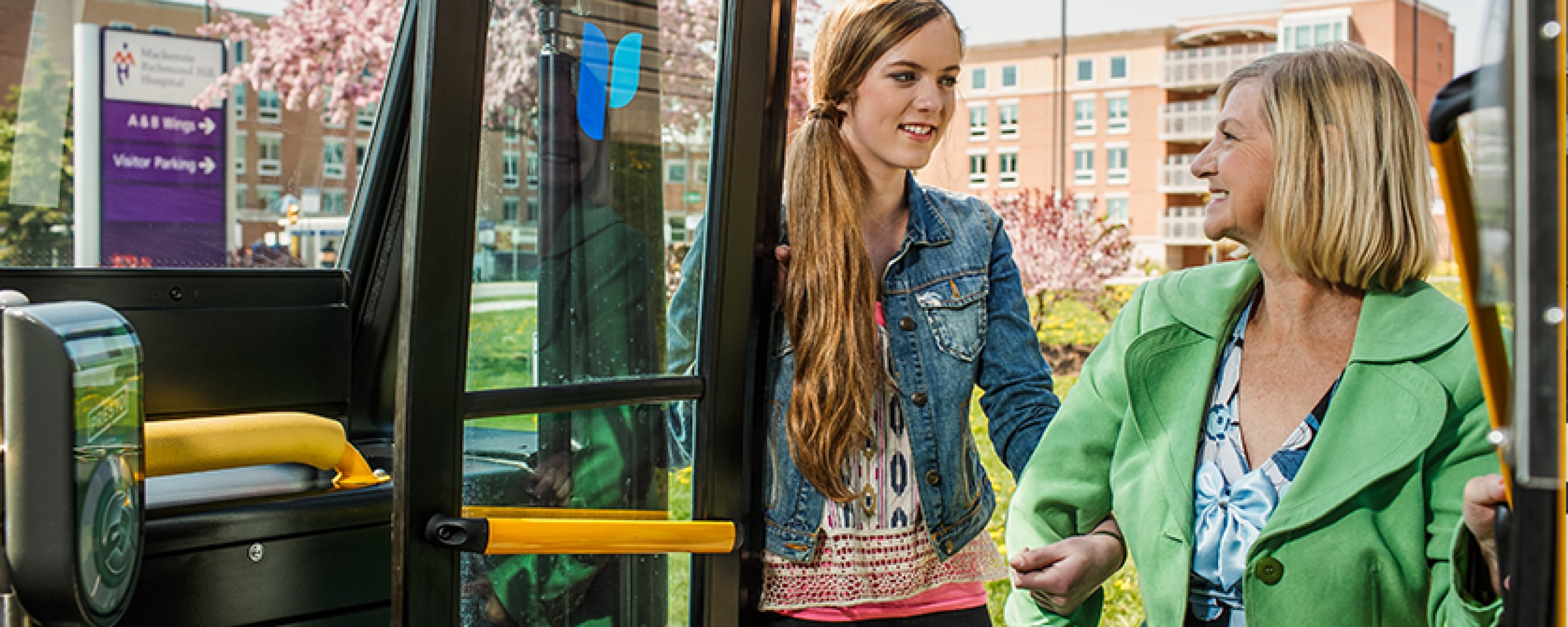 Banner image of a young woman assisting a woman boarding a bus