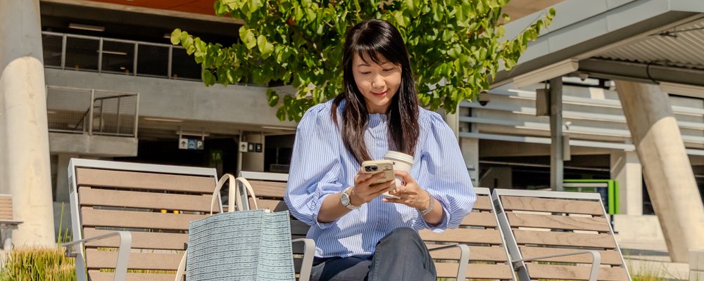 women sitting on a bench looking at her phone